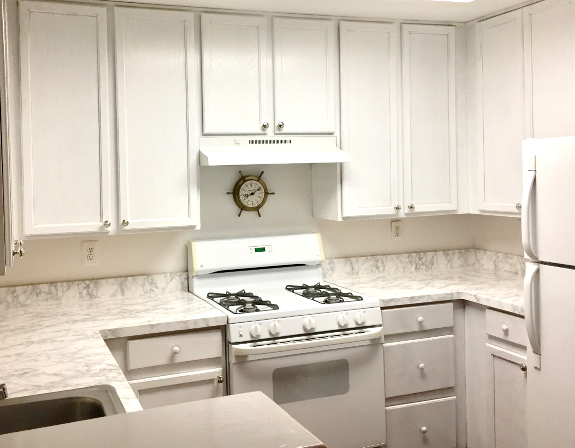 A kitchen with white cabinets

Description automatically generated